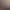 Trois lits simples avec des couvertures blanches et des coussins, séparés par une table en bois, dans une chambre mansardée avec une fenêtre éclairée par la lumière du soleil